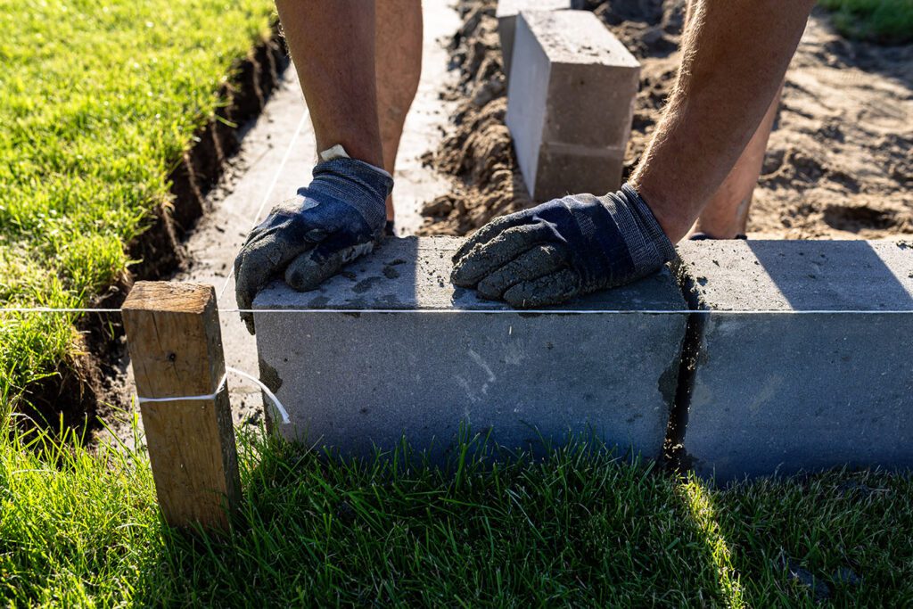 Landscaper-building-a-retaining-wall-for-landscape-bed